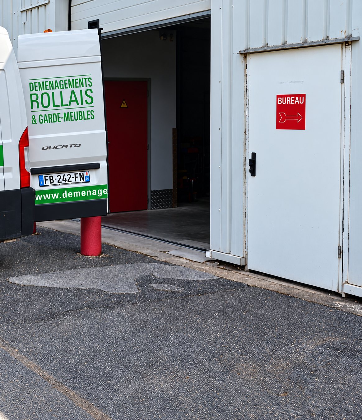 Garde-meubles : arrière de la camionnette Déménagements Rollais devant l'entrepôt, porte ouverte